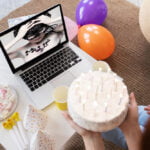 Open laptop of Bjork album cover on screen while person holds birthday cake